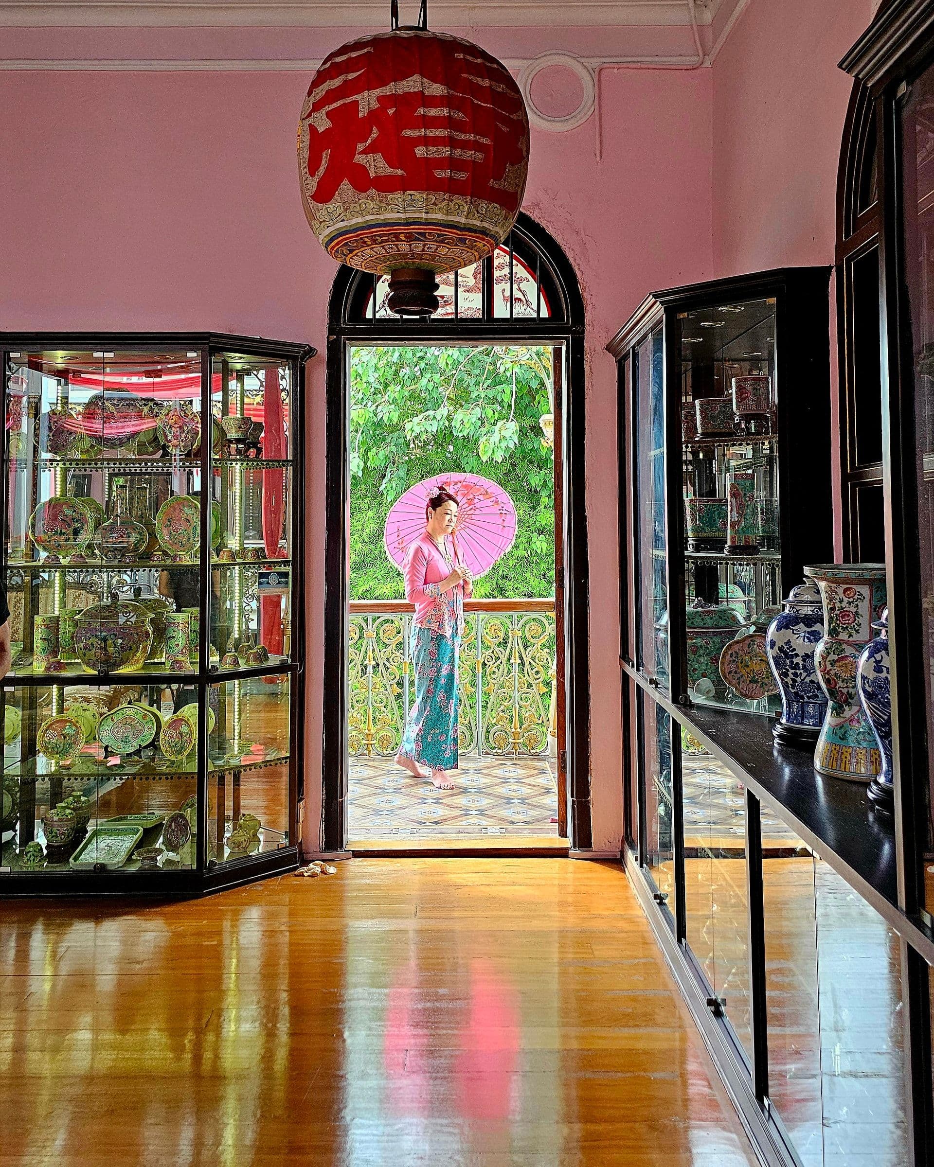 A richly decorated room in the Pinang Peranakan Mansion with carved-wood panels