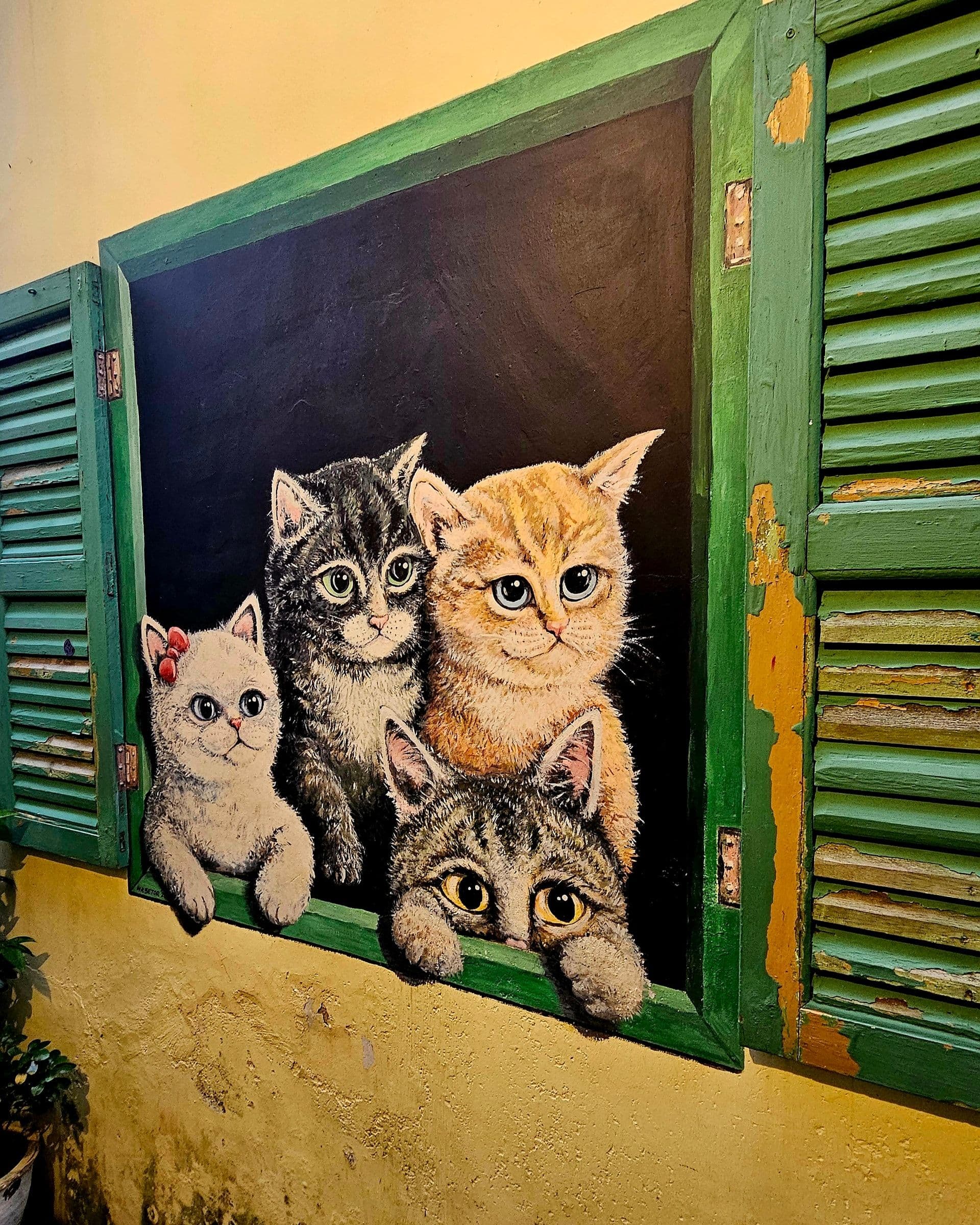 Cats in a Green Window mural at 14 Lebuh Cannon, painted cats looking out from a green window frame