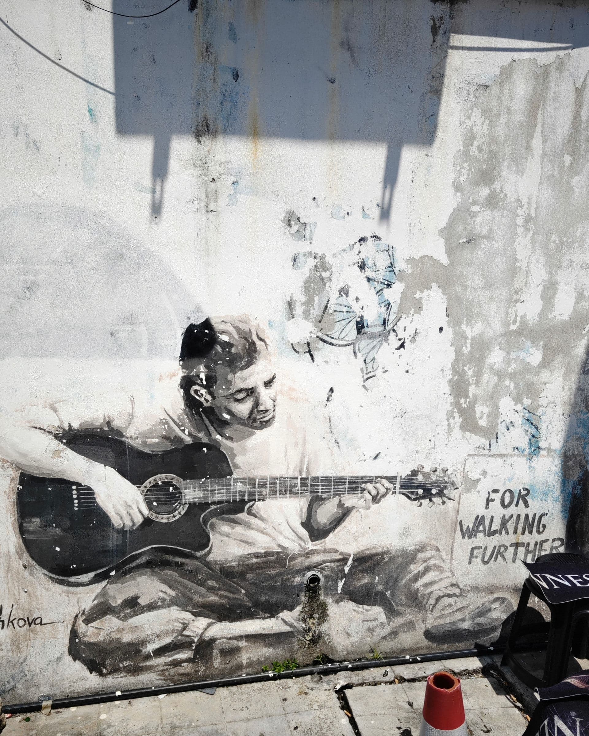 Street Busker mural by Julia Volchkova on Love Lane, a painted man playing an acoustic guitar